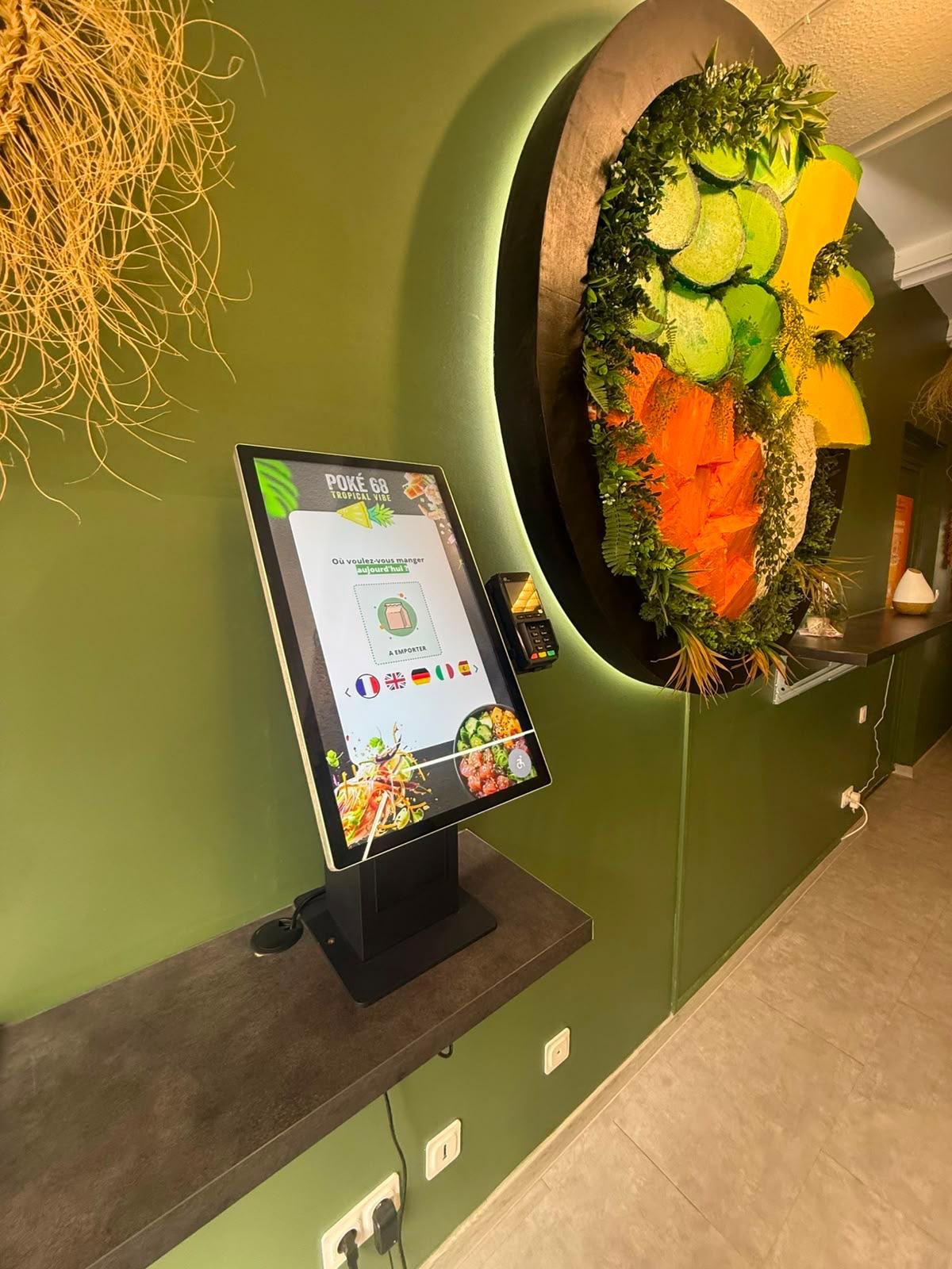 Borne de commande sur pied dans un restaurant de poke bowls, mur vert